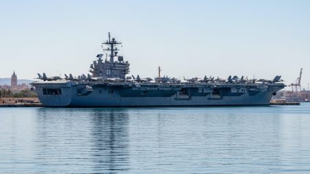 Flugzeugträger USS Gerald R. Ford erreicht Palma Der Flugzeugträger USS Gerald R. Ford liegt realistisch in der Bucht von Palma mit klar sichtbaren Flugzeugen auf dem Flugdeck und mediterranem Hafen im Hintergrund.