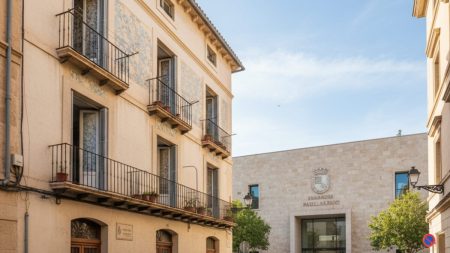 Straßenszene in Palma de Mallorca mit einem alten Wohnhaus und dem Balearen-Parlament im Hintergrund, symbolisch für ein illegales Gästehaus gegenüber dem Parlament
