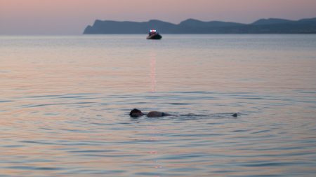 Toter in der Bucht von Alcúdia auf Mallorca gefunden Leiche in der Bucht von Alcúdia auf Mallorca im Wasser mit Rettungsboot im Hintergrund bei Abenddämmerung