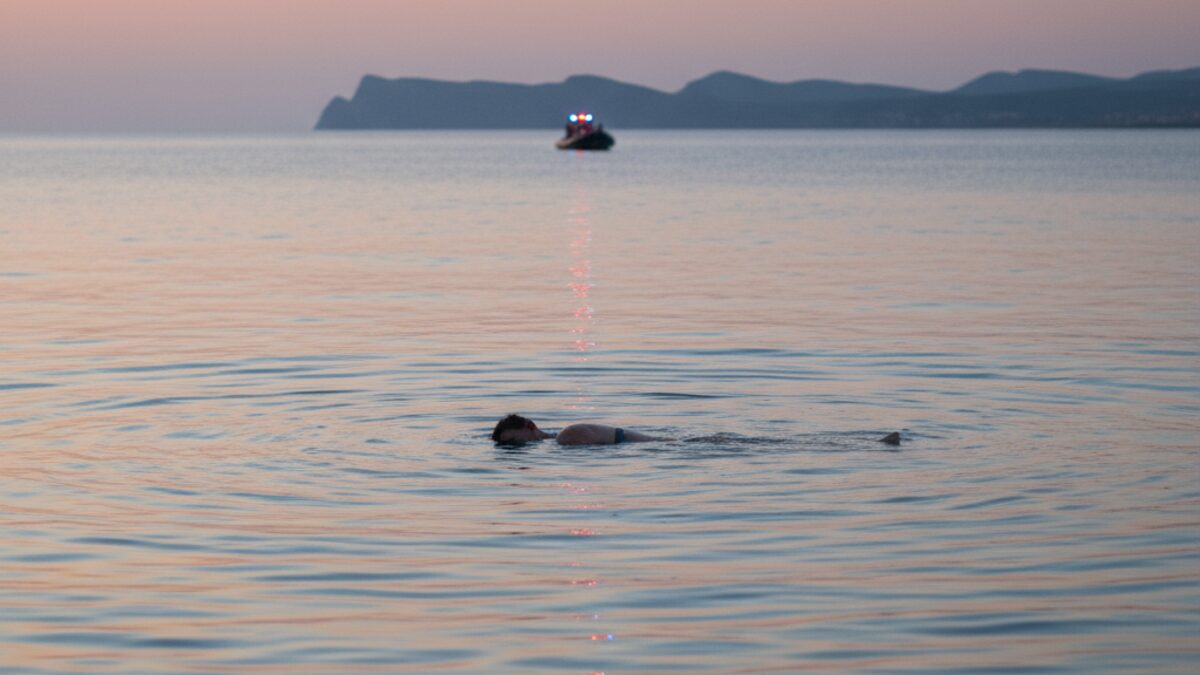 Leiche in der Bucht von Alcúdia auf Mallorca im Wasser mit Rettungsboot im Hintergrund bei Abenddämmerung
