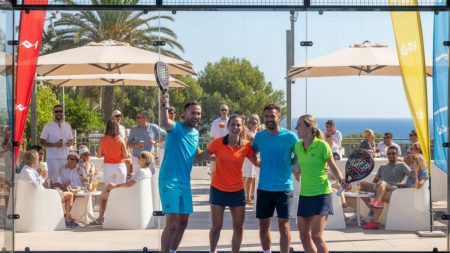 Padel Turnier auf Mallorca mit Spielern, die auf einem sonnigen Platz einen Sieg feiern, umgeben von einer freundlichen und sportlichen Atmosphäre