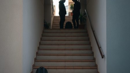 Eine Treppenhaus-Szene in einem Wohngebäude mit zwei Personen und einem Rucksack, symbolisch für den Raubüberfall und die Haftstrafe in Magalluf