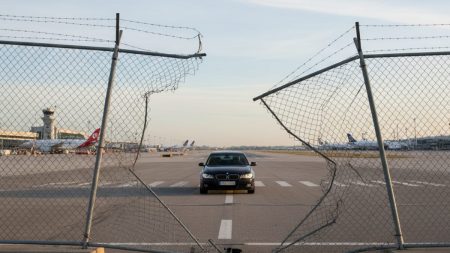 Beschädigter Sicherheitszaun am Flughafen Palma mit durchbrochenem Auto nahe der Landebahn am frühen Morgen