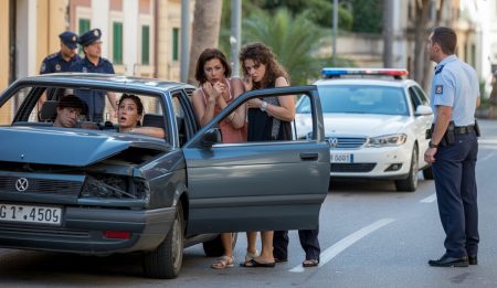 Aggressiver Fahrer flüchtet nach gefährlichem Vorfall auf Mallorca Ein beschädigtes Auto auf der Straße in Mallorca mit zwei betroffenen Frauen daneben.