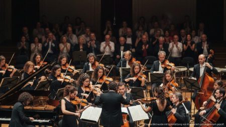 Orchester des OSIB bei glanzvollem Saisonstart in Barcelona mit Pianist und Dirigent auf einer elegant beleuchteten Bühne