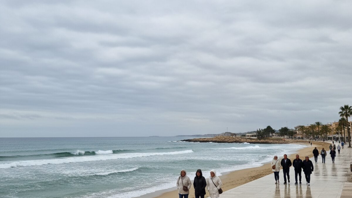 Promenade von Cala Millor unter einem dichten wolkenbedeckten Himmel mit Menschen in leichten Regenjacken bei milden Temperaturen
