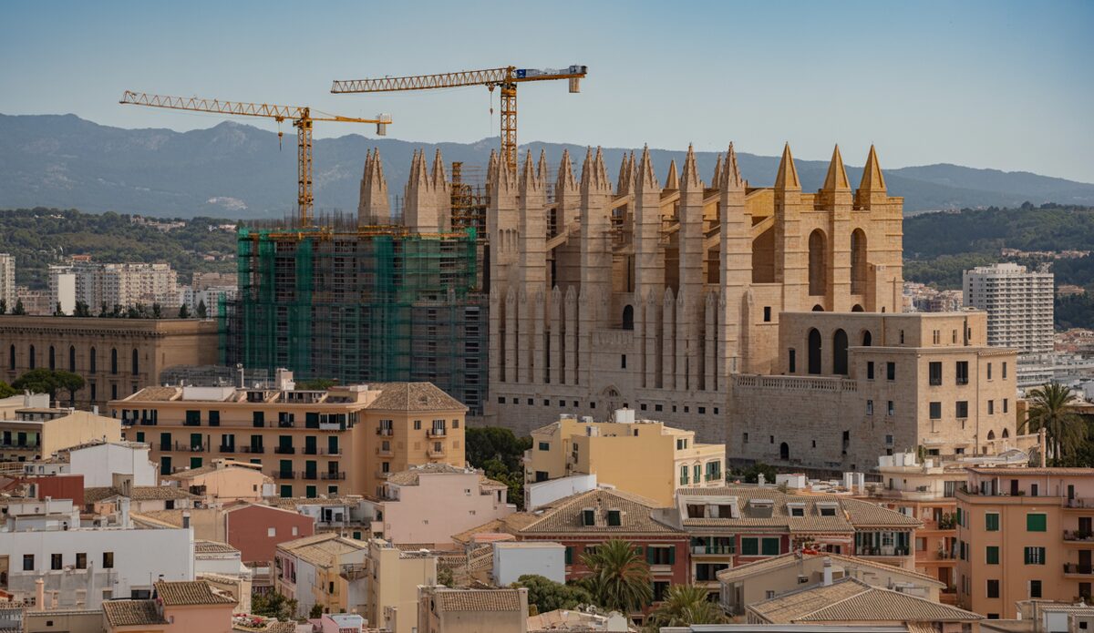 Baukräne vor Palmas Skyline mit Luxuswohnungen im Vordergrund.