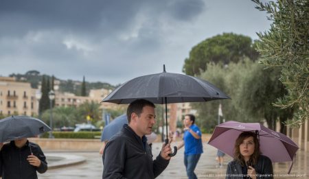 Leichter Regen in Santa Ponsa, Mallorca, Menschen mit Regenschirmen.