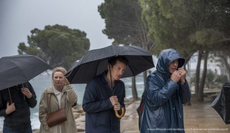 Stürmisches Wetter in Cala Millor mit Menschen in Regenkleidung