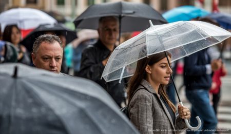 Regenwolken bringen milde Temperaturen nach Mallorca Menschen mit Regenschirmen auf Palmas Straßen bei Regenwetter