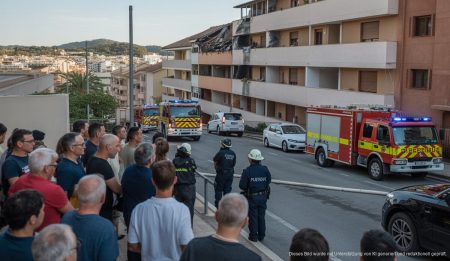 Wohngebäude mit beschädigtem Dach und Einsatzkräften in Palma de Mallorca.