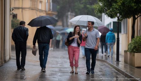 Regentag in Alcúdia, Mallorca mit grauem Himmel und Regenschirmen