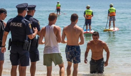 Nackte Touristen in Palma sorgen für Polizeieinsatz Touristen an der Playa de Palma, umgeben von Polizei und Rettungskräften.