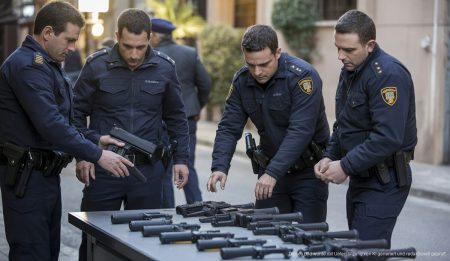 Polizisten bei einer Razzia in Palma de Mallorca mit beschlagnahmten Waffen.