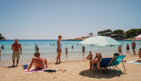 Hitze auf Mallorca: Strahlender Sonnenschein sorgt für angenehmes Badewetter Strahlender Sonnenschein auf einem Strand auf Mallorca mit Urlaubern und klarem Himmel