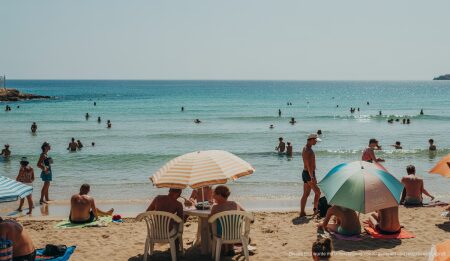 Hitze und tropische Nächte auf Mallorca setzen sich fort Strand in Palma de Mallorca während einer Hitzewelle, Menschen suchen Schatten.