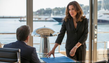 Jana Azizi startet als Immobilienmaklerin auf Mallorca durch Jana Azizi in einem Immobilienbüro in Puerto Portals, Mallorca, mit Immobilienplänen.