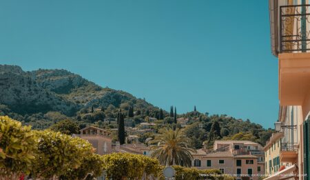 Angenehme Wetterbedingungen auf Mallorca: Sonne und milde Temperaturen in Sóller Strahlend blauer Himmel in Sóller, Mallorca, mit traditioneller Architektur und grünem Laub.